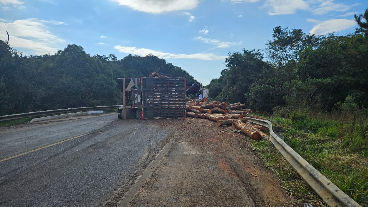 Bitrem bate em caminhão, tomba e derruba carga de madeira na BR-153